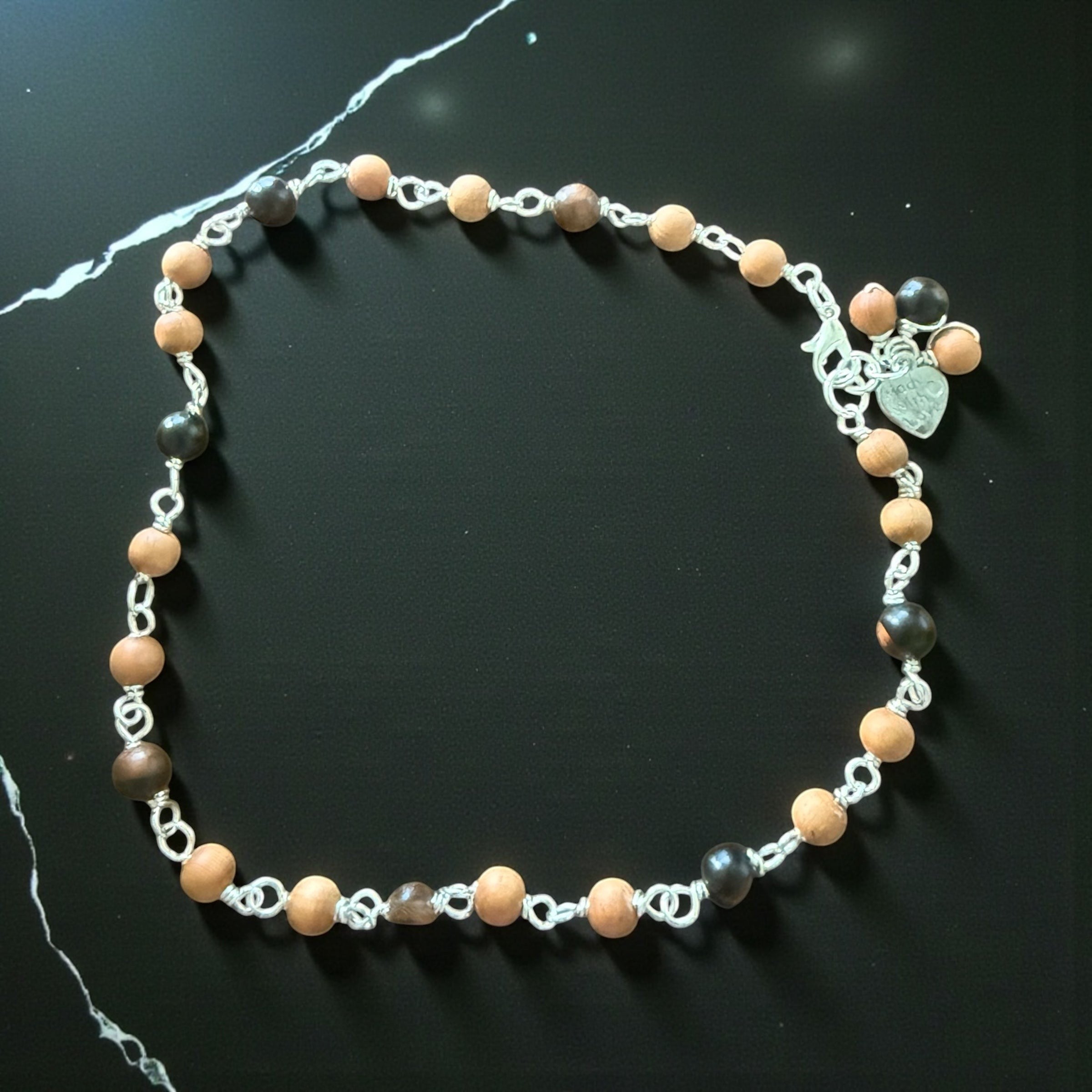 Jena Jewelry Sandalwood and Ebony Blackwood mala anklet with silver chain and heart charm. Features light wood and dark wood beads.