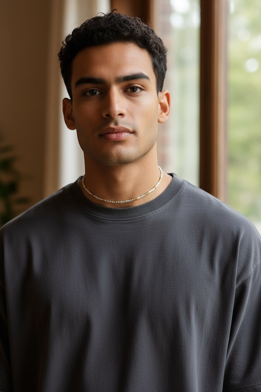 Jena Jewelry men's seed bead necklace with gold and silver beads, worn with a dark grey t-shirt.