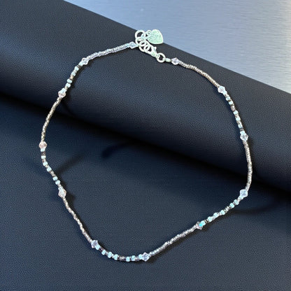 Jena Jewelry delicate seed bead necklace with white, pink, and clear crystal beads. Features a silver clasp and heart charm.