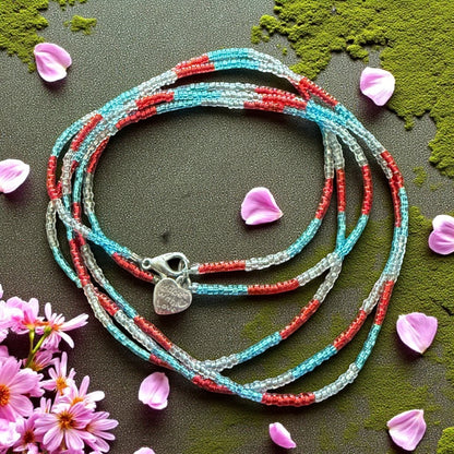 Jena Jewelry handcrafted seed bead wrap bracelet in red, light blue, and clear. Features a heart charm.