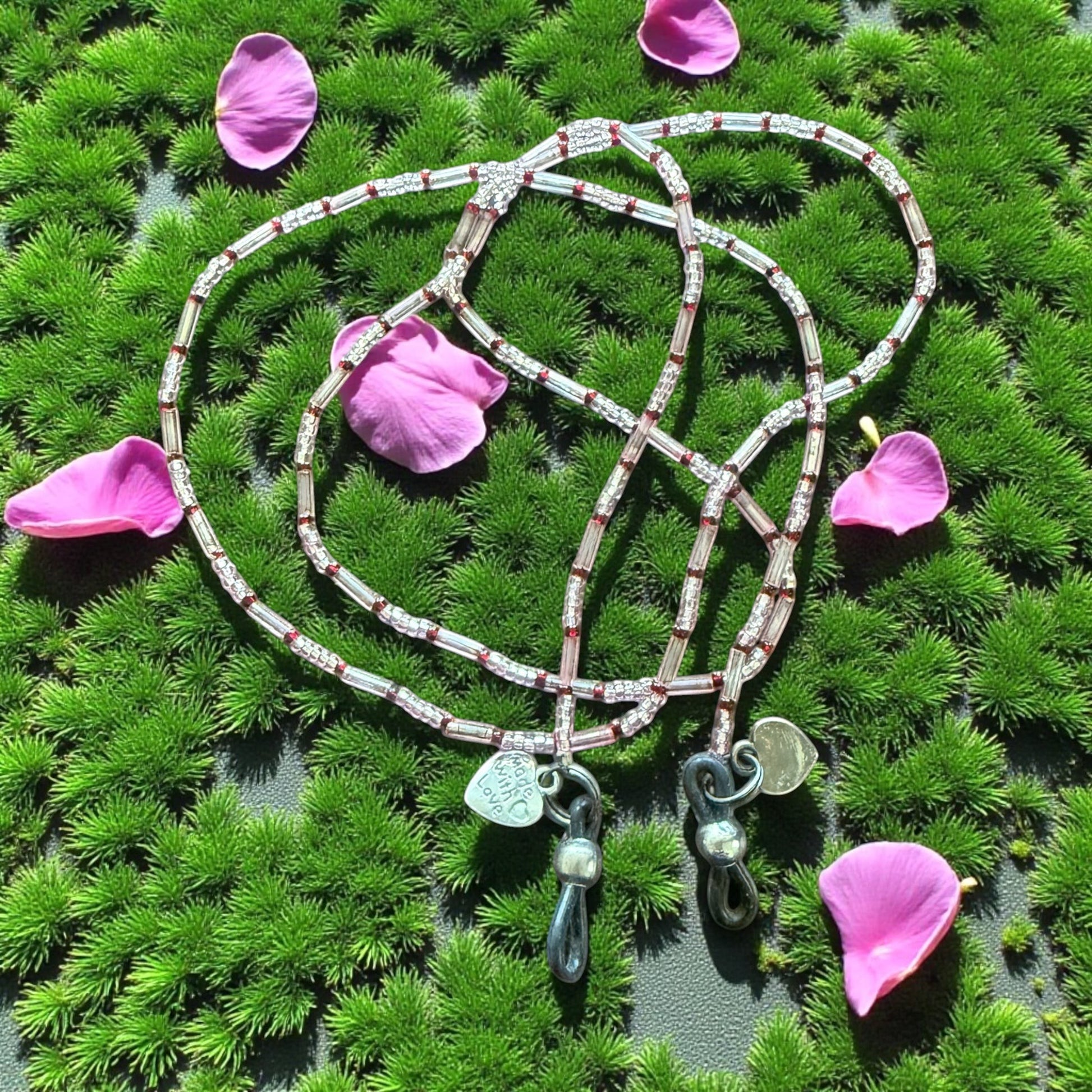 Jena Jewelry handcrafted seed bead wrap bracelet and glasses holder with clear, silver, and red beads and silver charms.