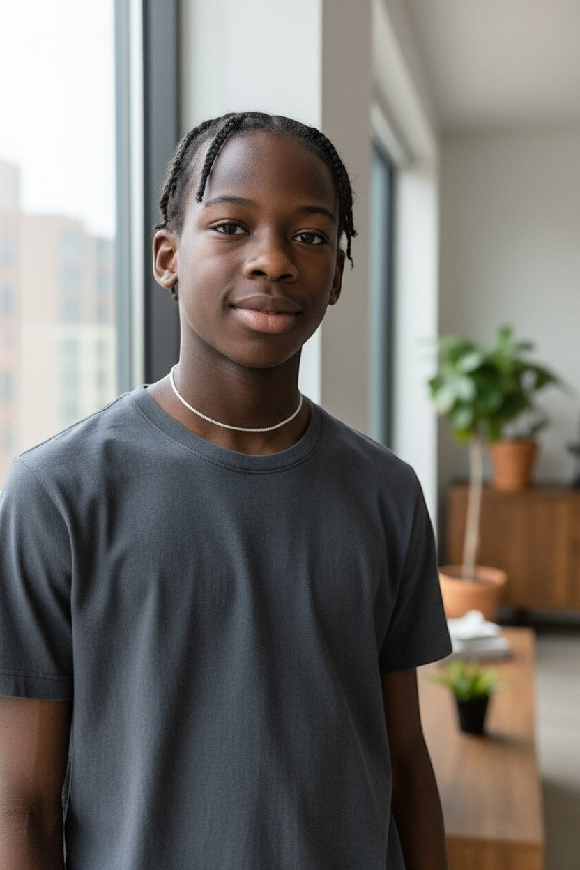 Jena Jewelry minimalist silver seed bead necklace on a young Black male model wearing a dark grey t-shirt.