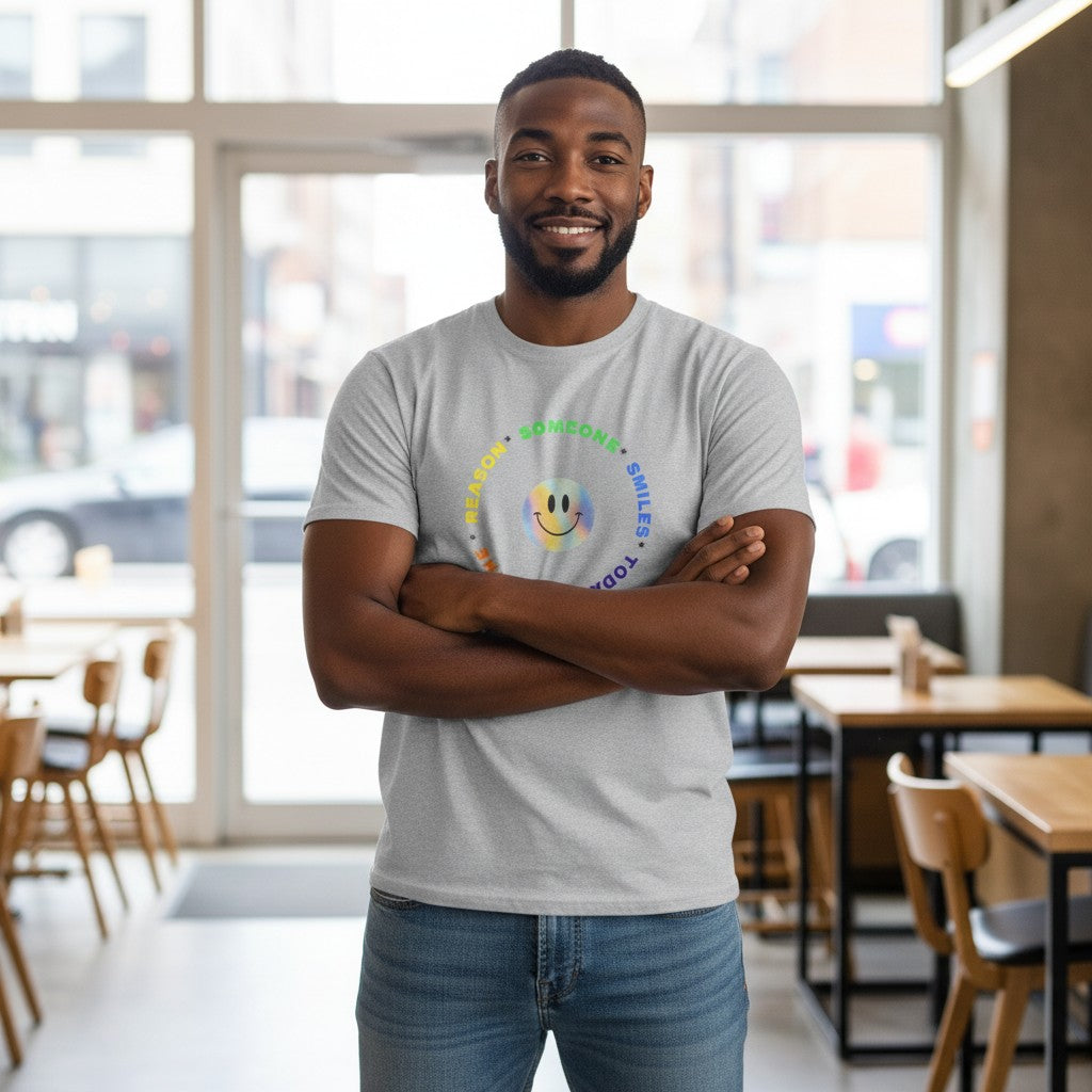 Jena Jewelry grey 100% cotton t-shirt with a rainbow smiley face graphic and text "Be The Reason Someone Smiles Today" in a circle.