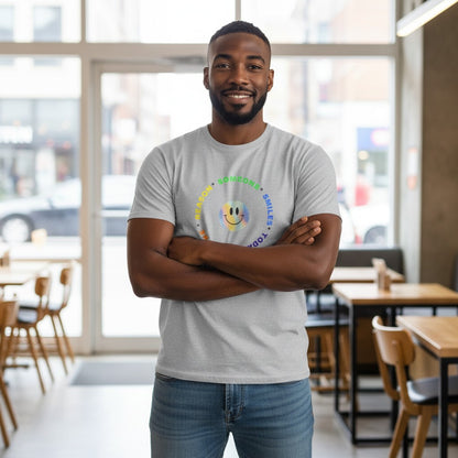 Jena Jewelry grey 100% cotton t-shirt with a rainbow smiley face graphic and text "Be The Reason Someone Smiles Today" in a circle.