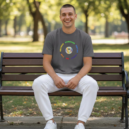 Jena Jewelry dark grey 100% cotton t-shirt with a rainbow smiley face graphic and "Be The Reason Someone Smiles Today" text.