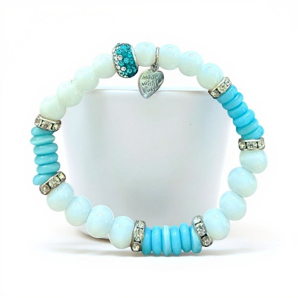 Jena Jewelry handmade stretch bracelet with white snow jade, blue cat eye disks, and rhinestone spacers. Features a "made with love" charm.