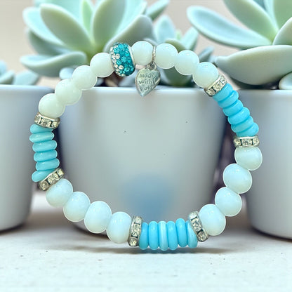 Jena Jewelry handmade stretch bracelet with white snow jade, blue cat eye disks, and rhinestone spacers. Features a heart charm.