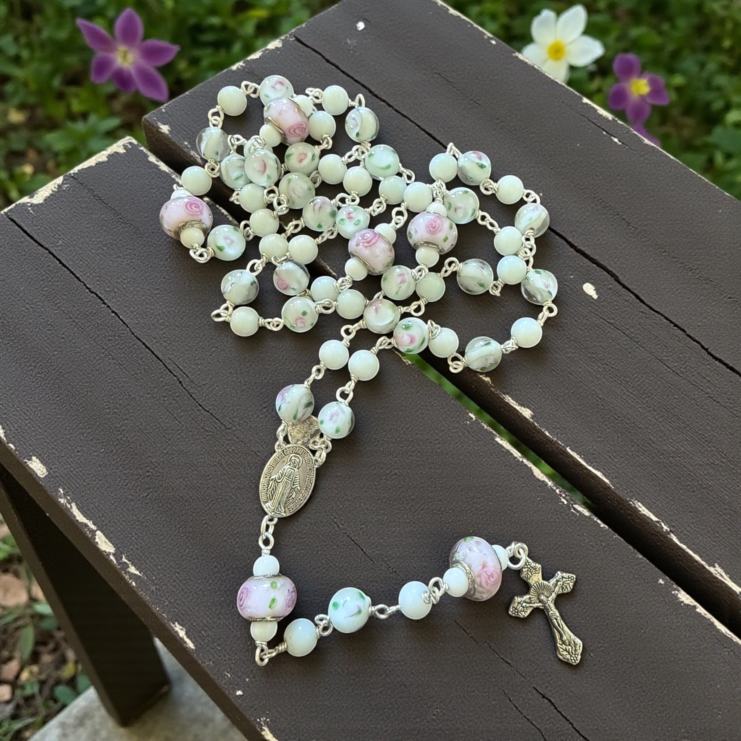 Jena Jewelry Snow Jade and Antique Floral Lampwork Rosary with silver crucifix and medallion. Features white jade beads and lampwork glass beads with pink floral designs.