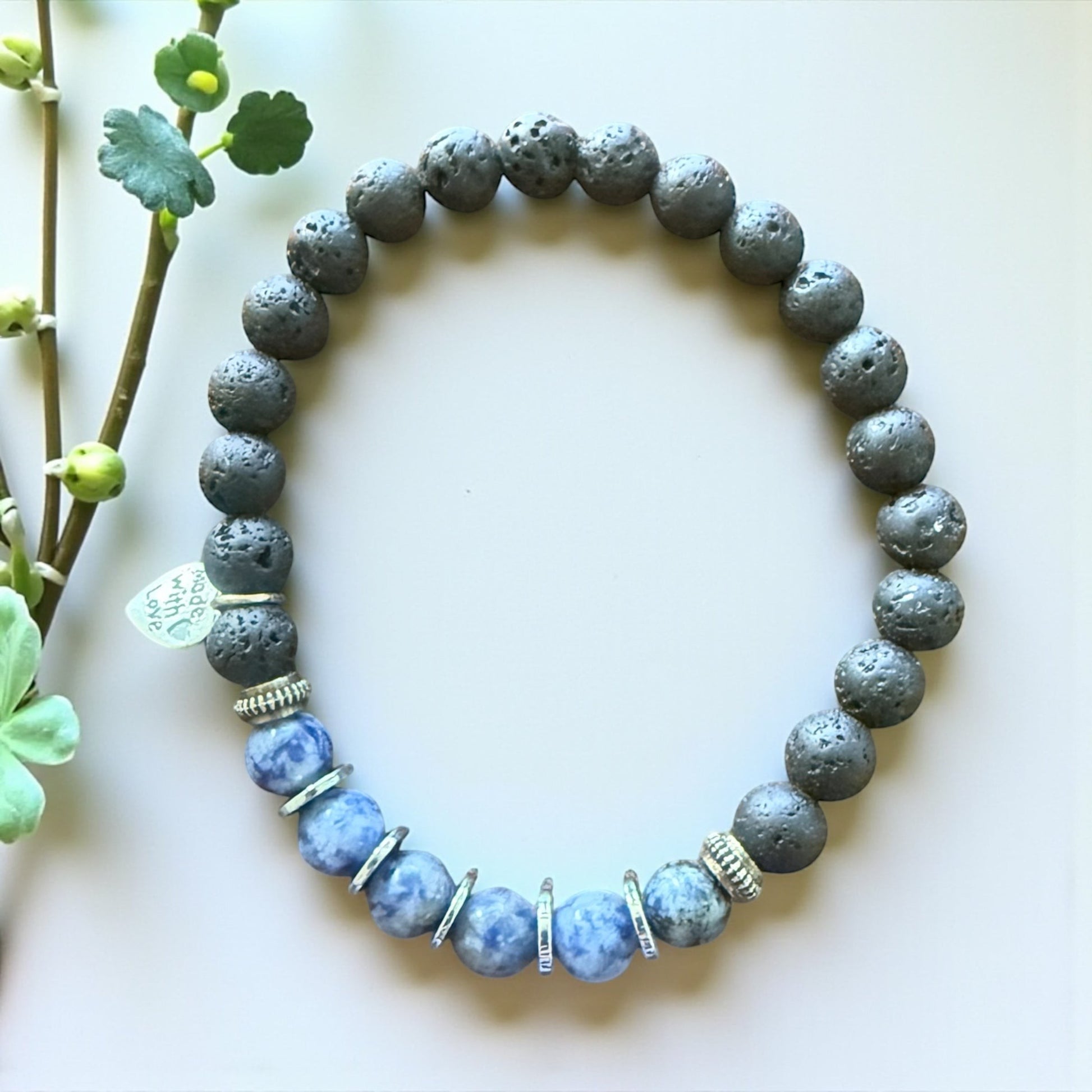 Jena Jewelry sodalite, hematite, and lava stone stretch bracelet with silver accents. Blue sodalite beads alternate with dark grey lava stone beads.