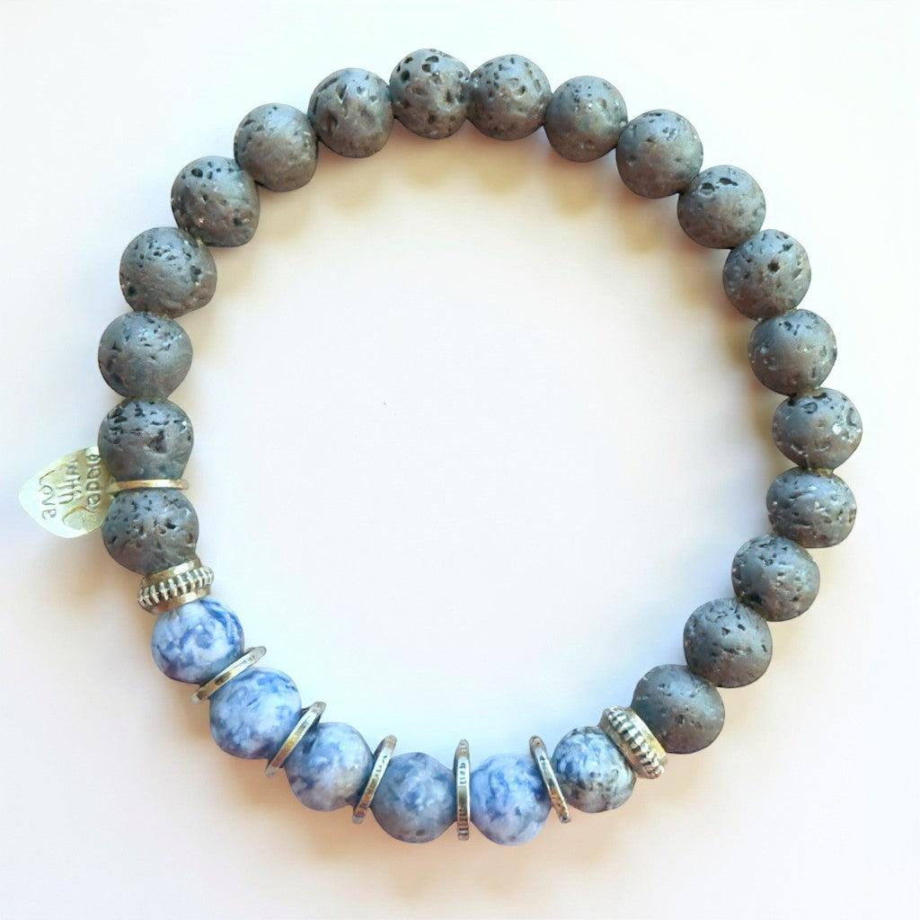 Jena Jewelry sodalite, hematite, and lava stone stretch bracelet with silver accents. Blue marbled sodalite beads alternate with dark grey porous lava stones.