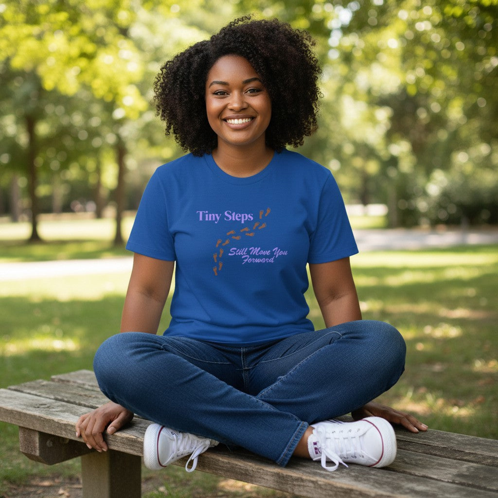 Jena Jewelry royal blue 100% cotton t-shirt with "Tiny Steps" and footprints graphic in lavender and orange.