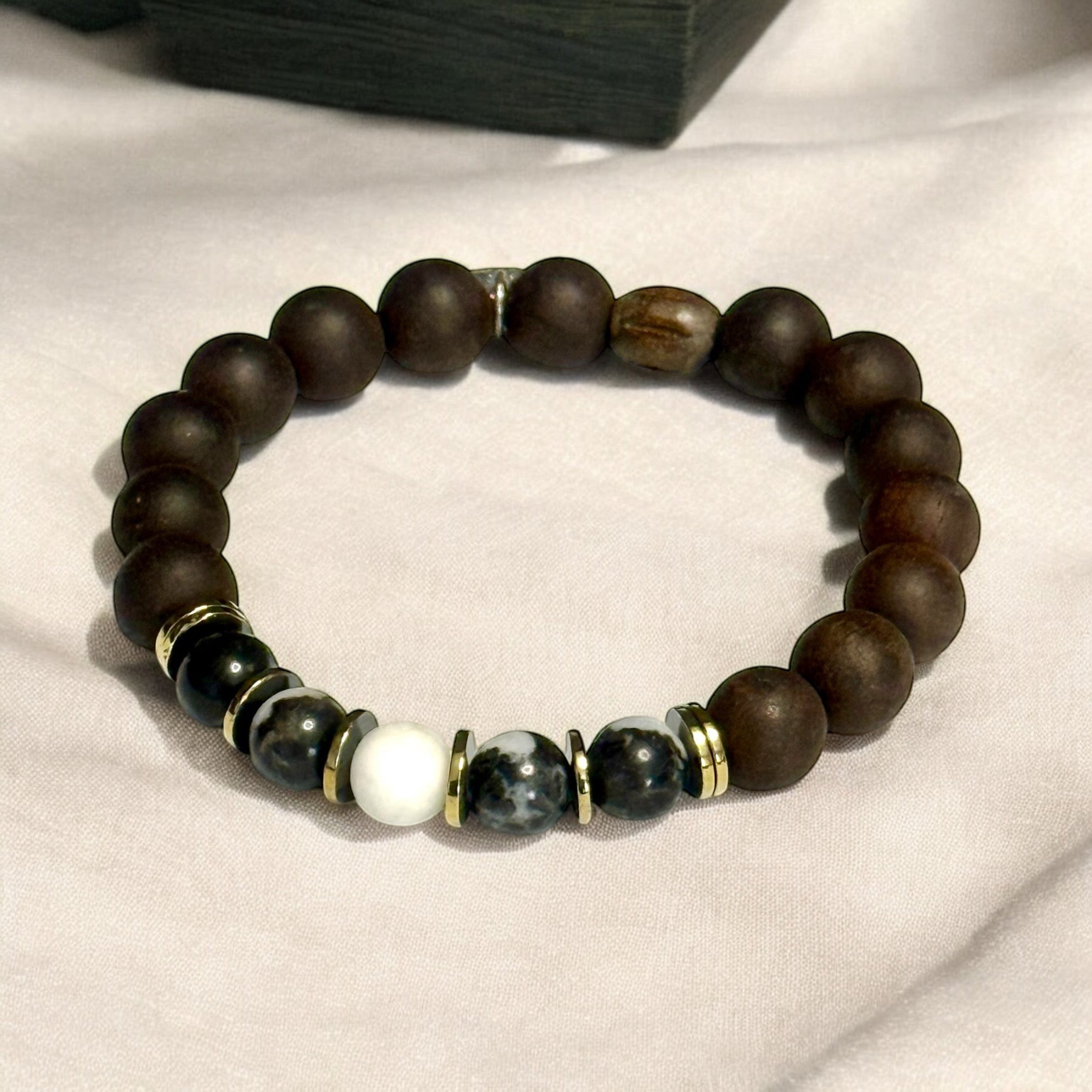 Jena Jewelry stretch bracelet with dark brown wood beads, black and white zebra jasper, and gold accents. Designed for grounding and energy.