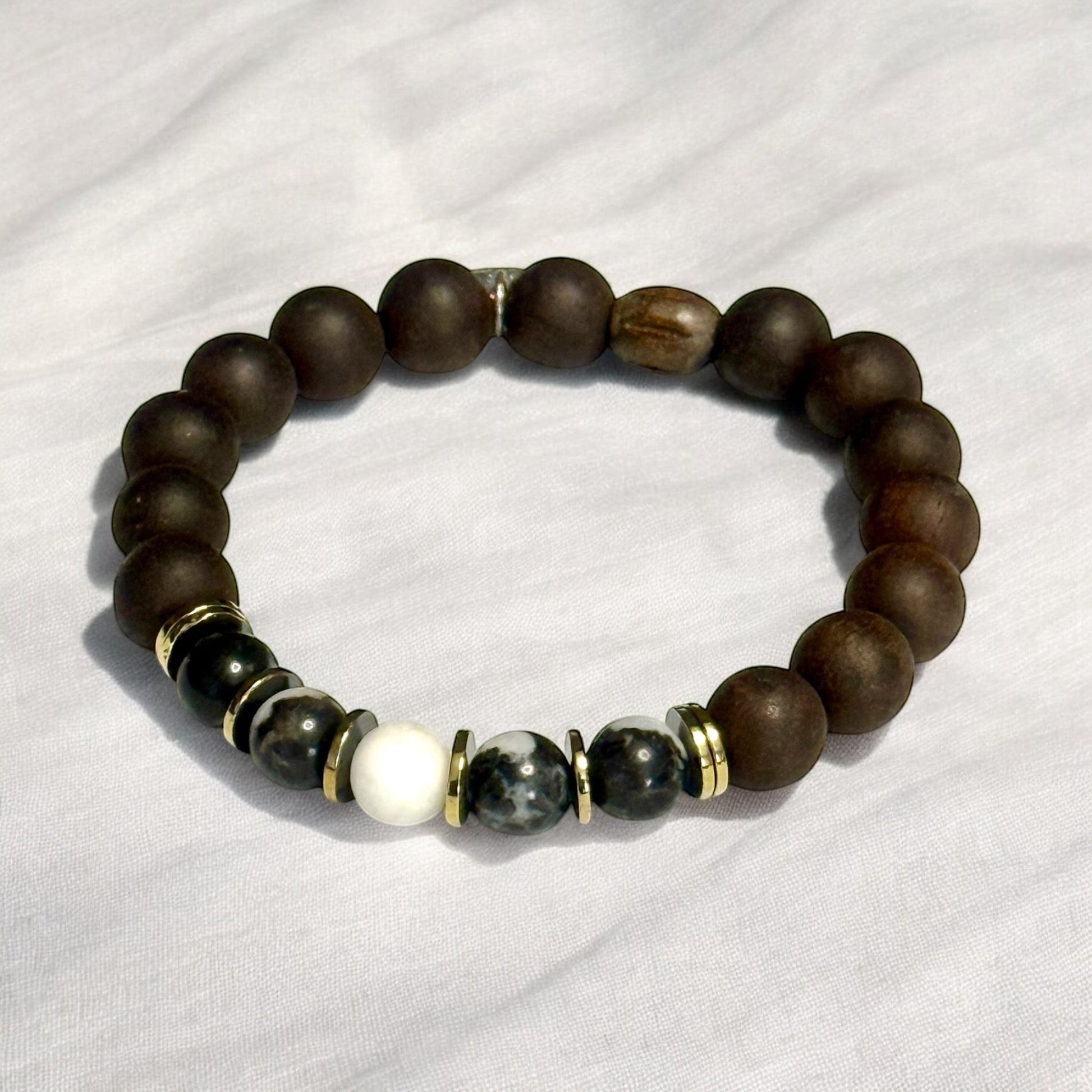 Jena Jewelry stretch bracelet with Zebra Jasper, Ebony Blackwood mala beads, and Hematite, accented with gold spacers.