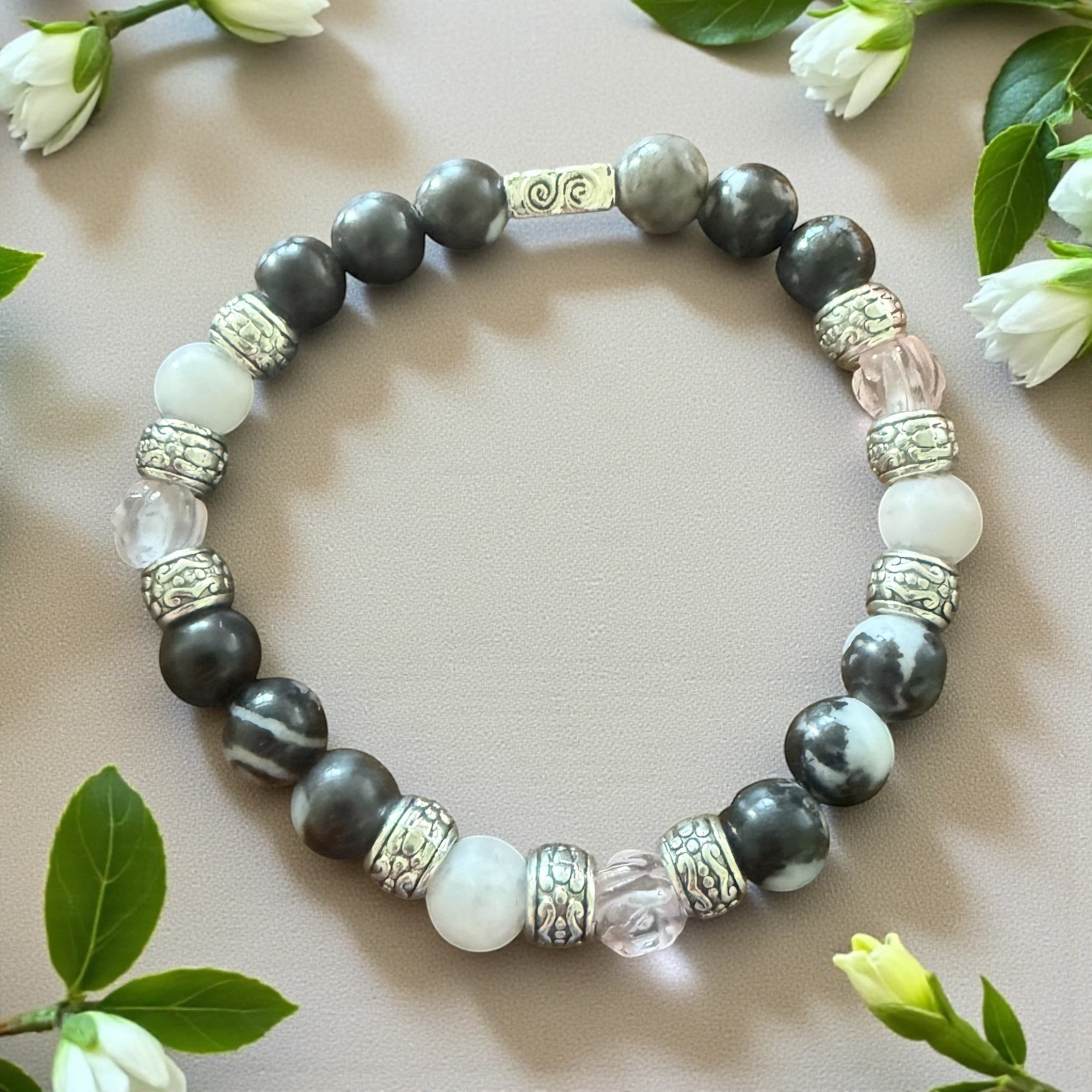 Jena Jewelry stretch bracelet with zebra jasper, rose quartz, white jade, and silver beads, featuring a central silver accent.
