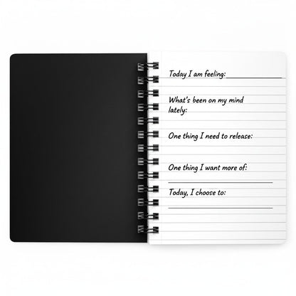 Jena Jewelry Guided Reset Journal, a black spiral notebook with lined pages for self-care and goal setting.