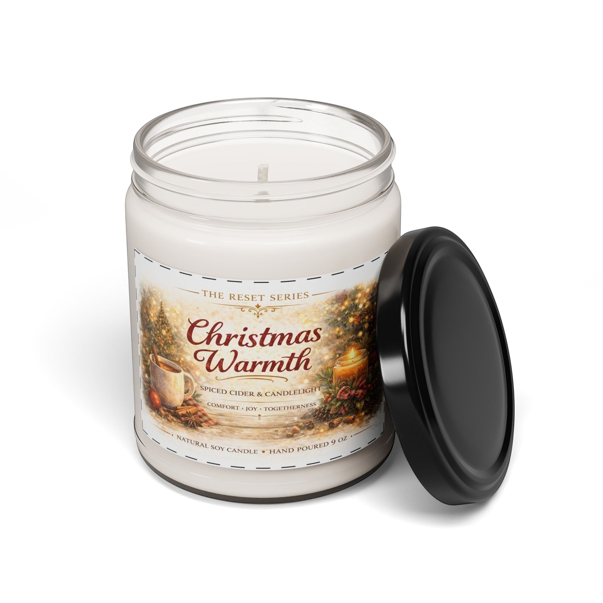 Jena Jewelry Christmas Warmth natural soy candle in a clear glass jar with a black lid. Festive label with holiday scene, warm spice, sweet citrus, and cozy woods scent.