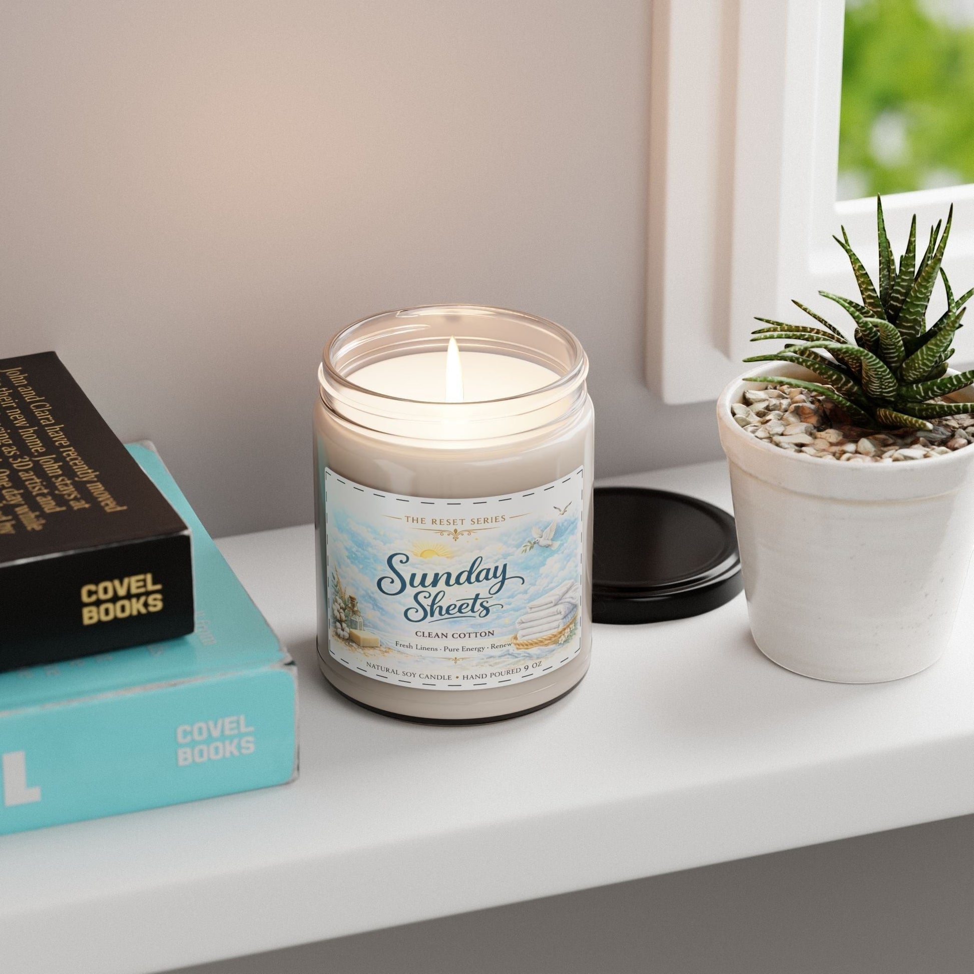 Jena Jewelry Clean Cotton scented soy candle with a fresh linen scent, in a reusable glass vessel with a glossy label.