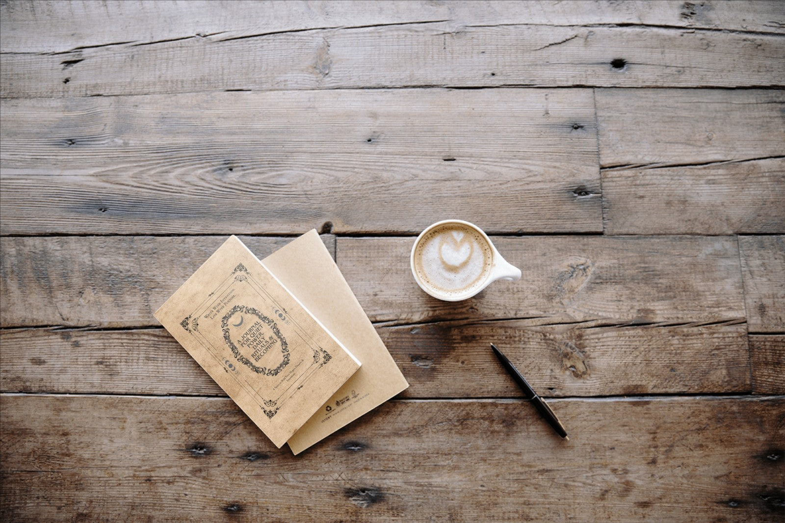 Jena Jewelry Daily Ritual Journal & Planner with latte art coffee and pen on rustic wooden table.