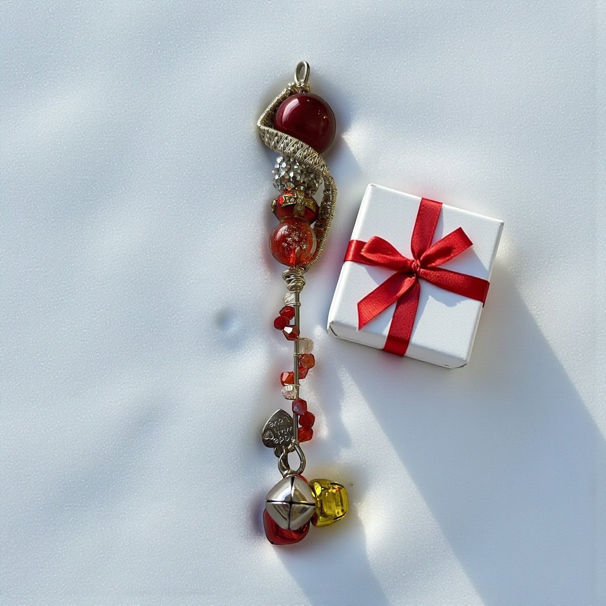 Jena Jewelry handcrafted festive icicle ornament with red glass beads, crystals, charms, and jingle bells.