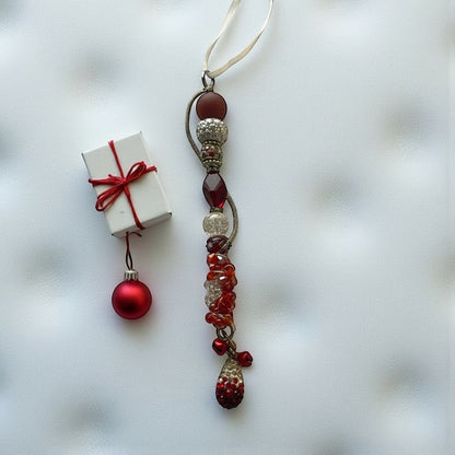 Jena Jewelry handcrafted festive icicle ornament with red and silver beads, charms, and jingle bells. Includes a small gift box.