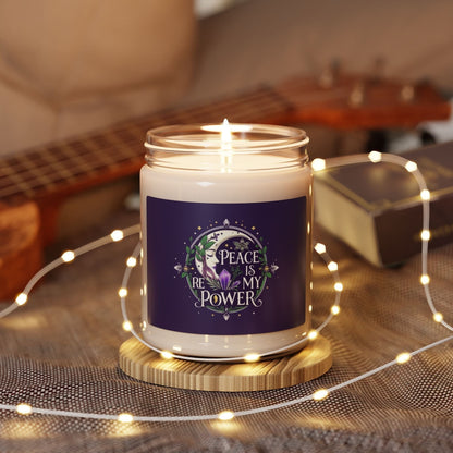 Jena Jewelry "Peace Is My Power" floral affirmation candle in a glass jar with a purple label, lit and surrounded by fairy lights.