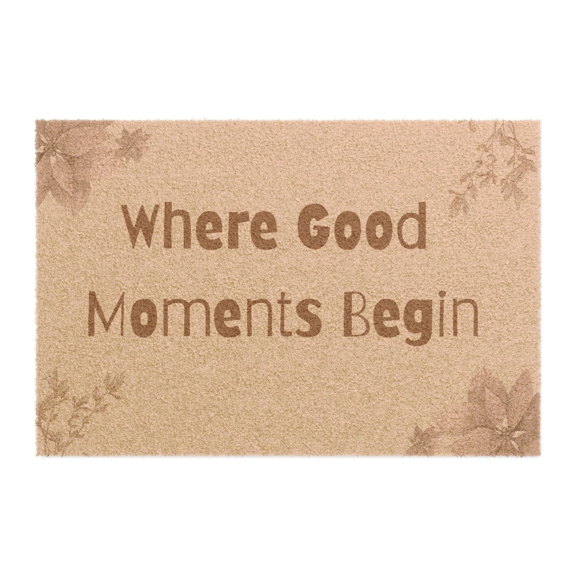 Jena Jewelry natural coir doormat with "Where Good Moments Begin" text and floral accents. Outdoor entryway mat.