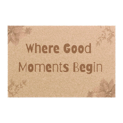 Jena Jewelry natural coir doormat with "Where Good Moments Begin" text and floral accents. Outdoor entryway mat.