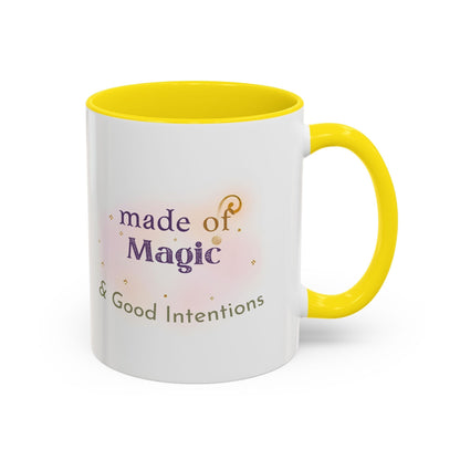 Jena Jewelry white ceramic mug with yellow interior and handle, featuring "made of Magic & Good Intentions" text and watercolor accents.