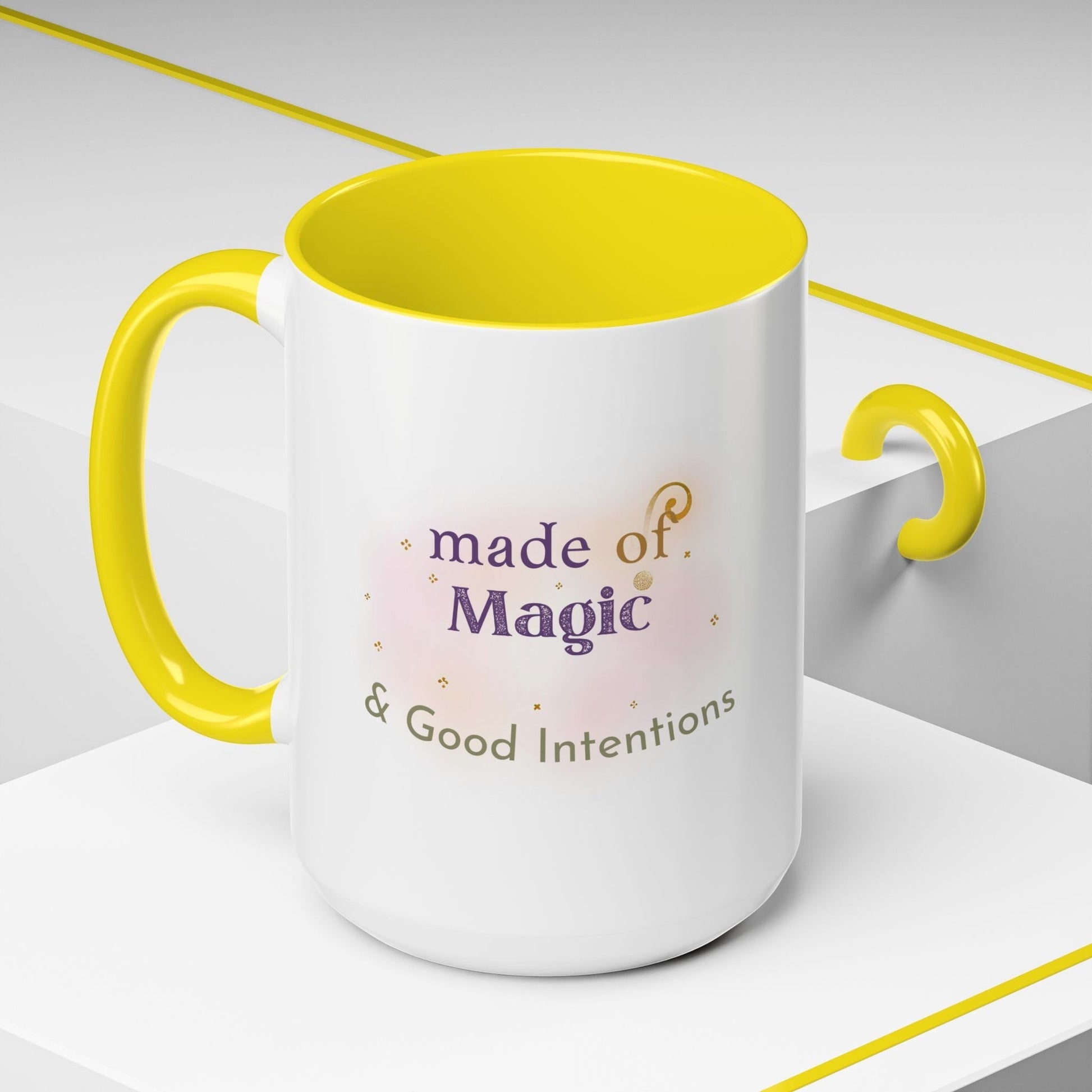 Jena Jewelry white ceramic mug with yellow interior and handle, featuring "Made of Magic & Good Intentions" text.