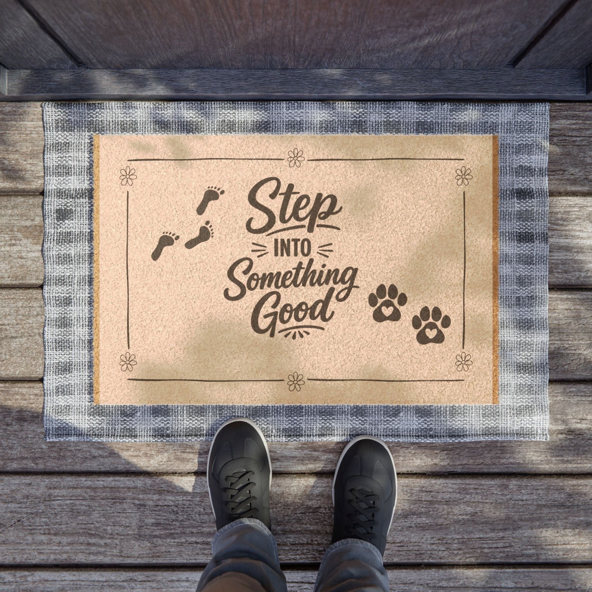 Jena Jewelry natural coir doormat with "Step Into Something Good" text, paw prints, and footprints. Features a blue plaid border.