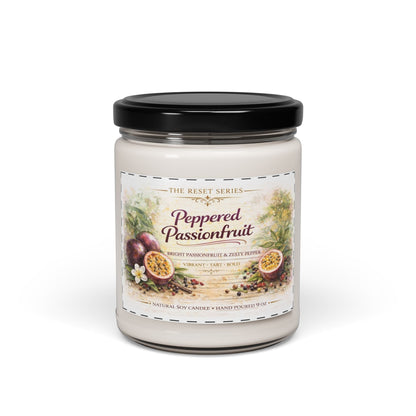 Jena Jewelry Peppered Passionfruit natural soy candle in a clear glass jar with a black lid. Features a label with passionfruit illustrations and scent notes.