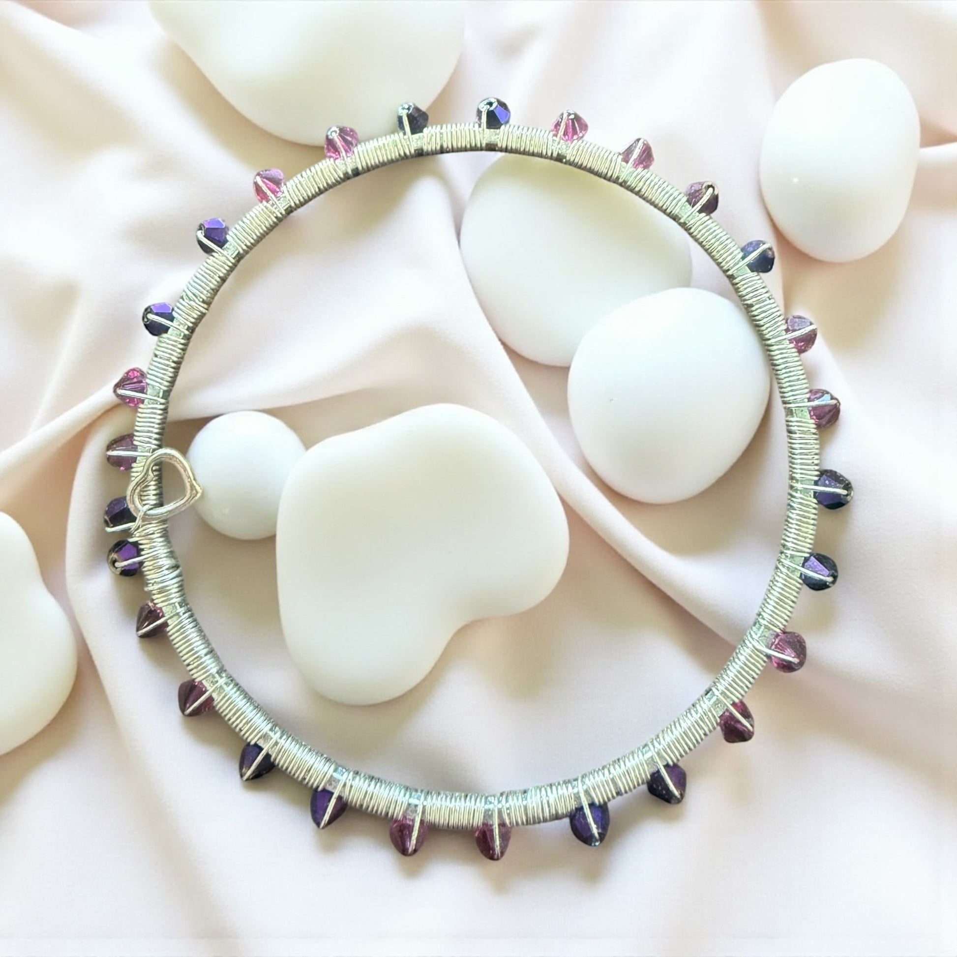 Jena Jewelry handmade wire-wrapped bangle bracelet with pink and purple crystals and a heart-shaped clasp.