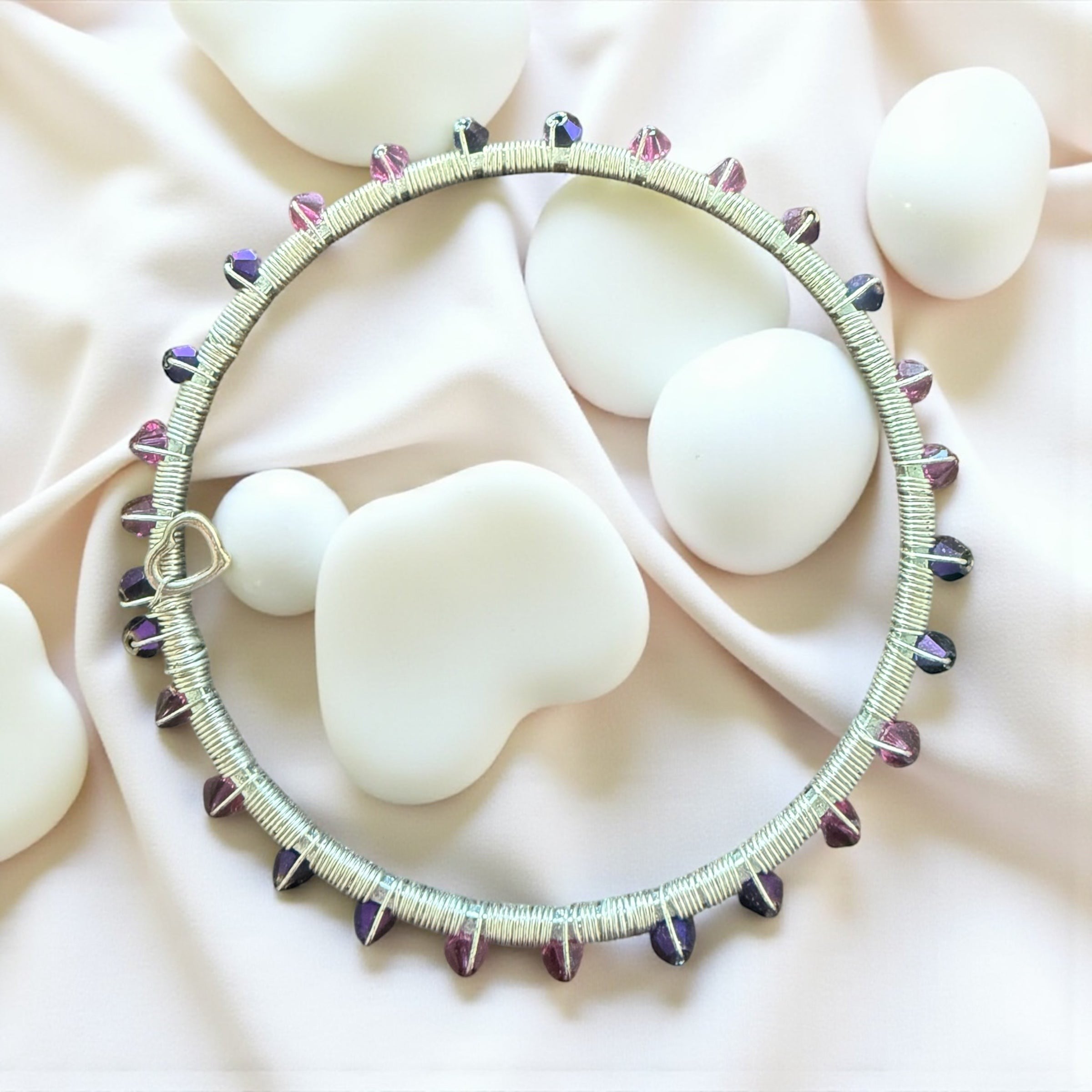 Jena Jewelry handmade wire-wrapped bangle bracelet with pink and purple crystals and a heart-shaped clasp.