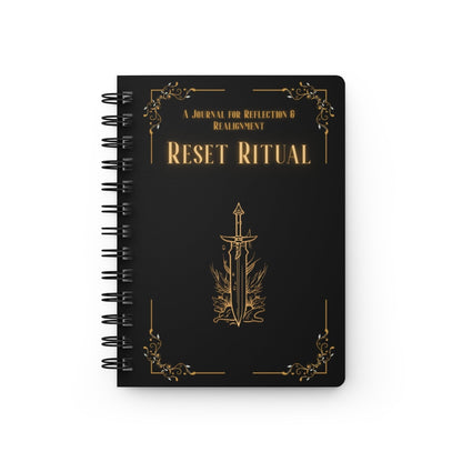 Jena Jewelry Reset Ritual spiral notebook with black cover, gold text and sword emblem. For self-care and goal setting.