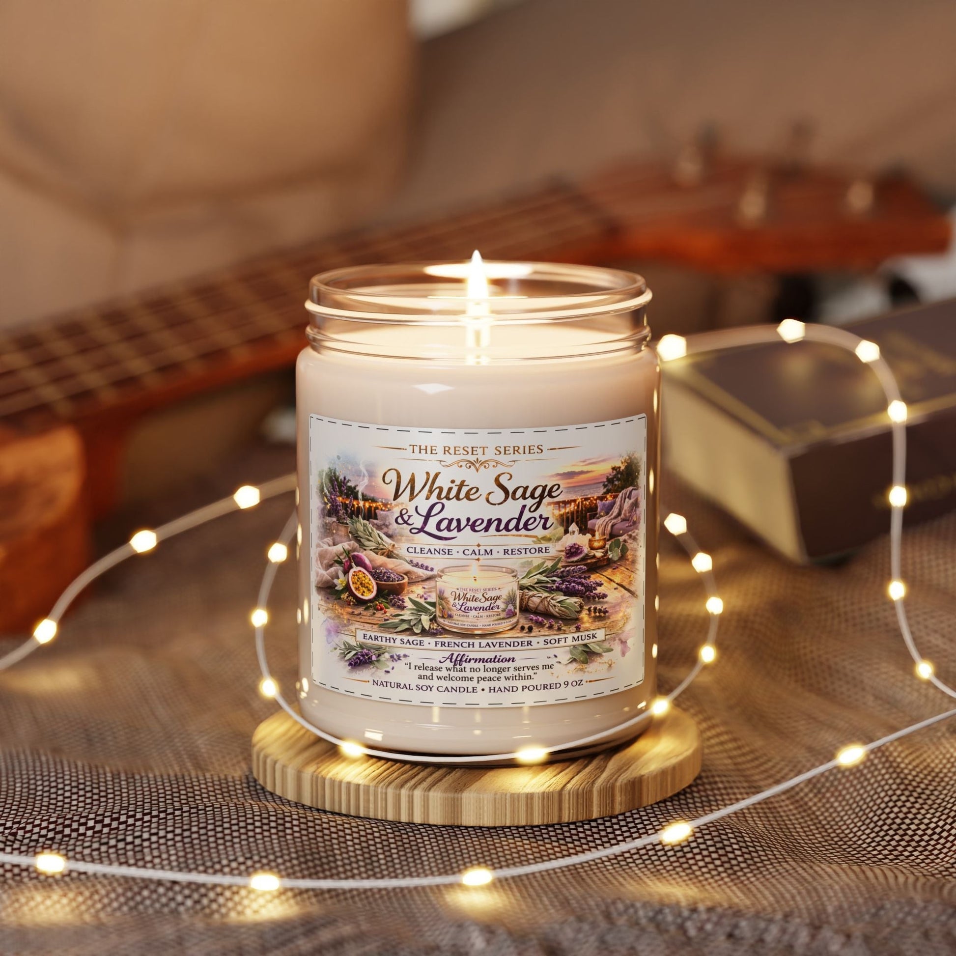 Jena Jewelry White Sage & Lavender soy candle in a glass jar, lit and on a wooden coaster, surrounded by fairy lights.