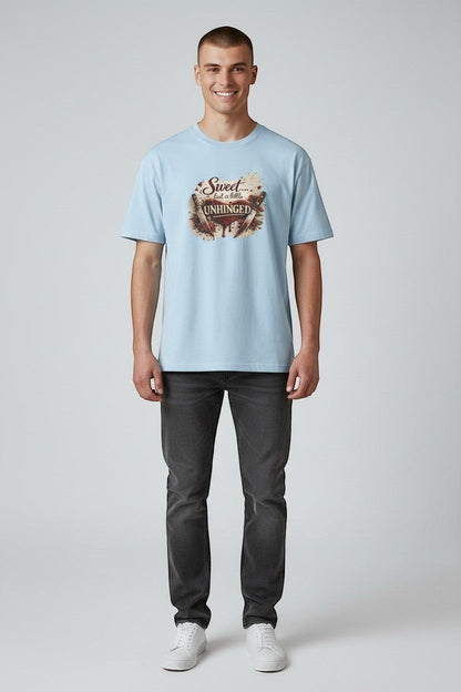 Man wearing light blue “Sweet but a Little Unhinged” shirt, a playful graphic tee for everyday style.