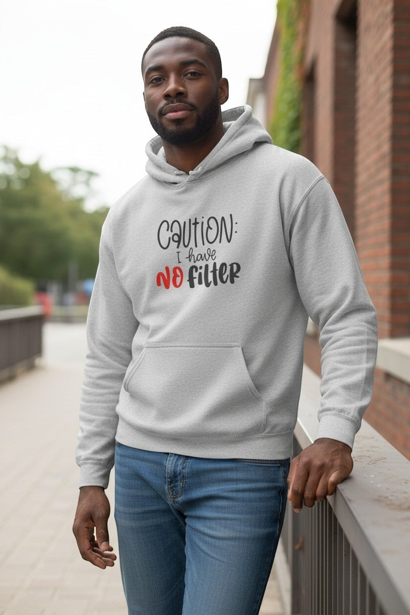 Man wearing grey “Caution I Have No Filter” hoodie outdoors, a stylish and humorous streetwear look.