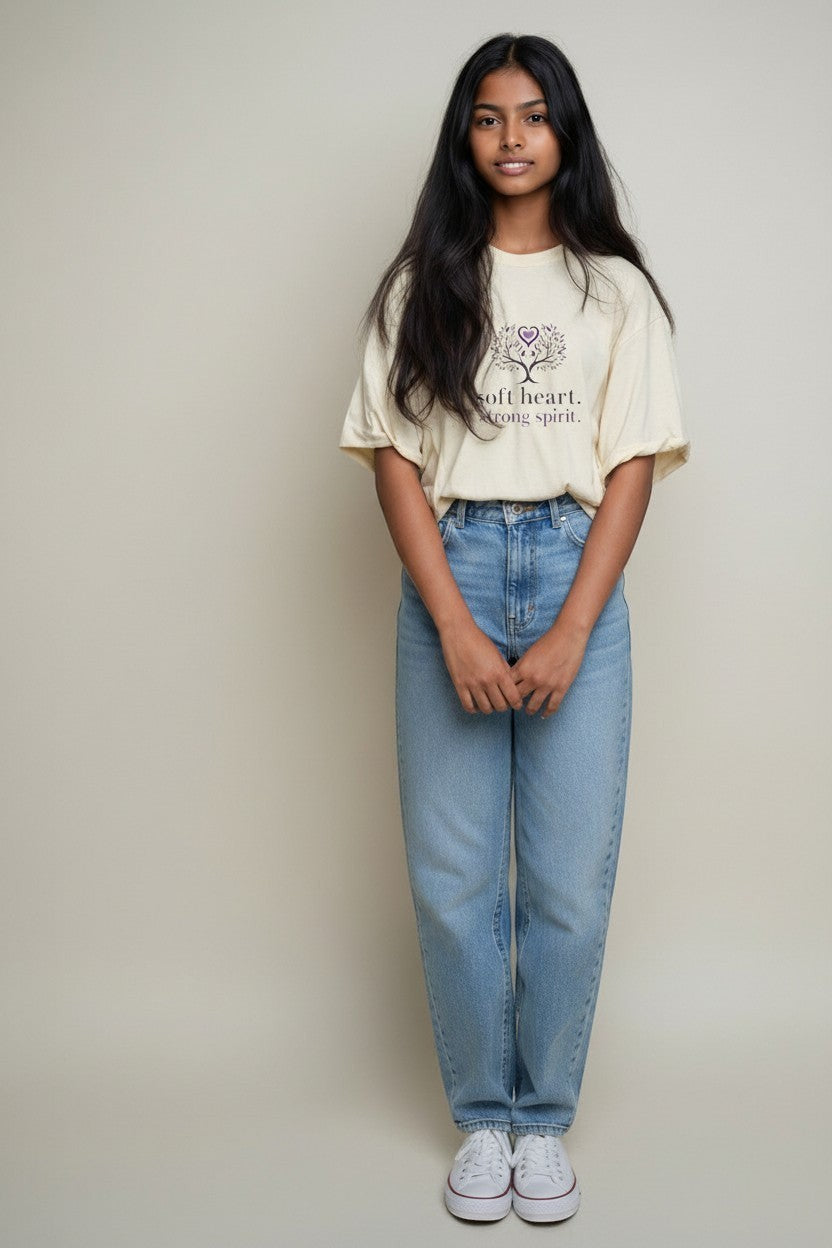 Woman wearing neutral beige “Soft Heart Strong Spirit” t-shirt, a clean and minimal everyday outfit.