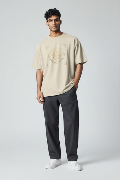 Man wearing neutral beige t-shirt with geometric spiritual design, a grounded and minimal everyday outfit.