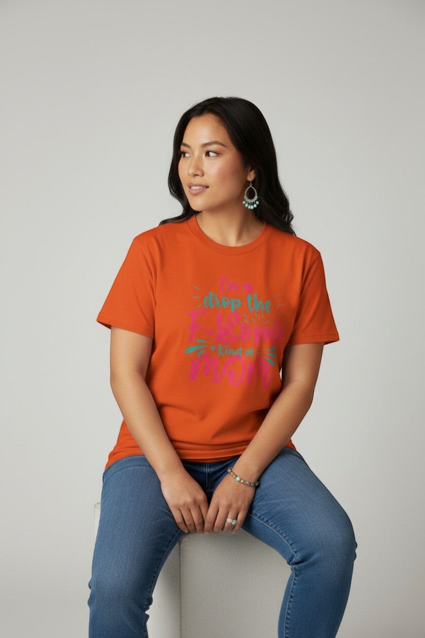 Woman wearing orange “Drop the F-Bomb Mom” t-shirt, a bright and eye-catching style.