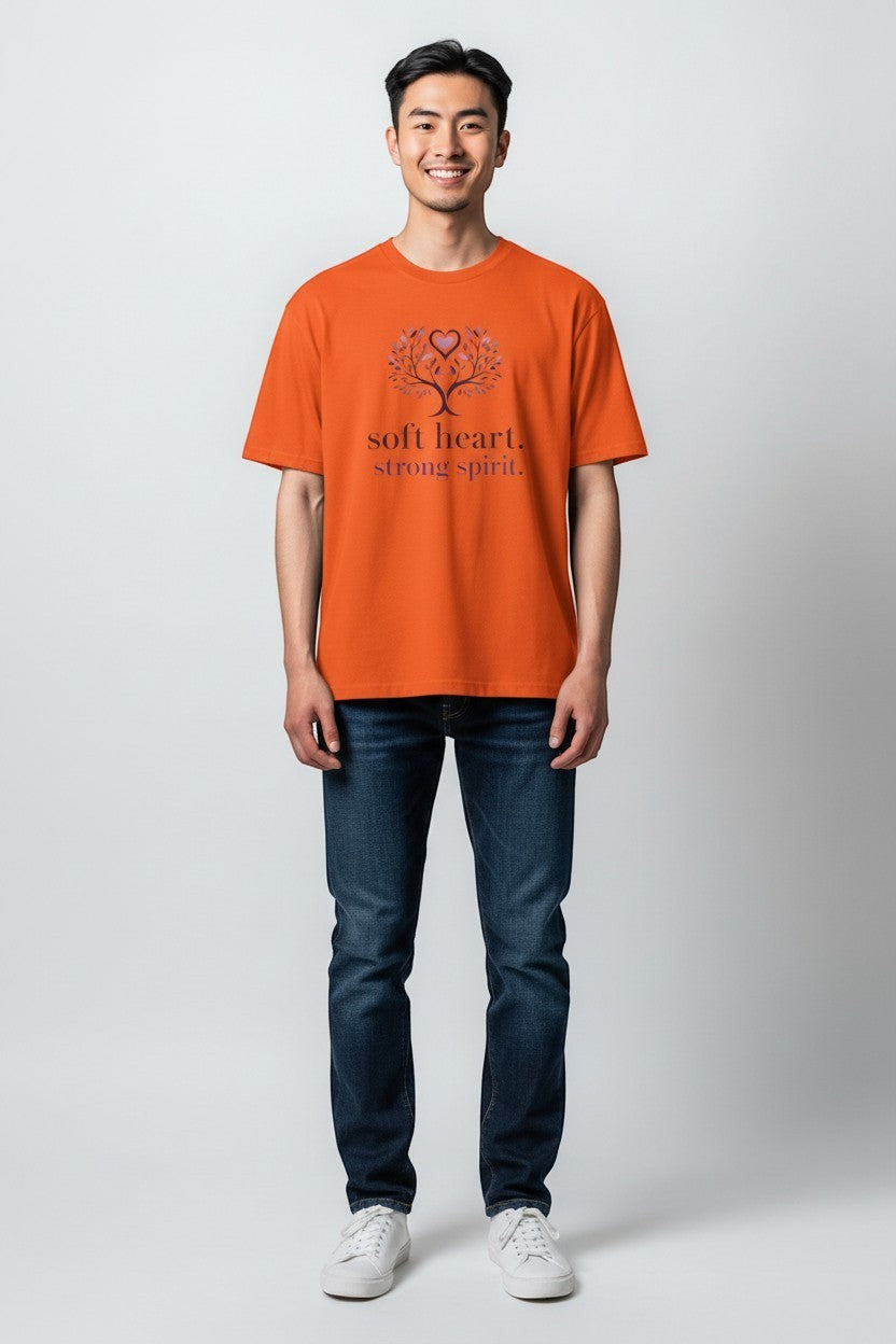 Man wearing orange “Soft Heart Strong Spirit” t-shirt, a bright and energetic casual style.