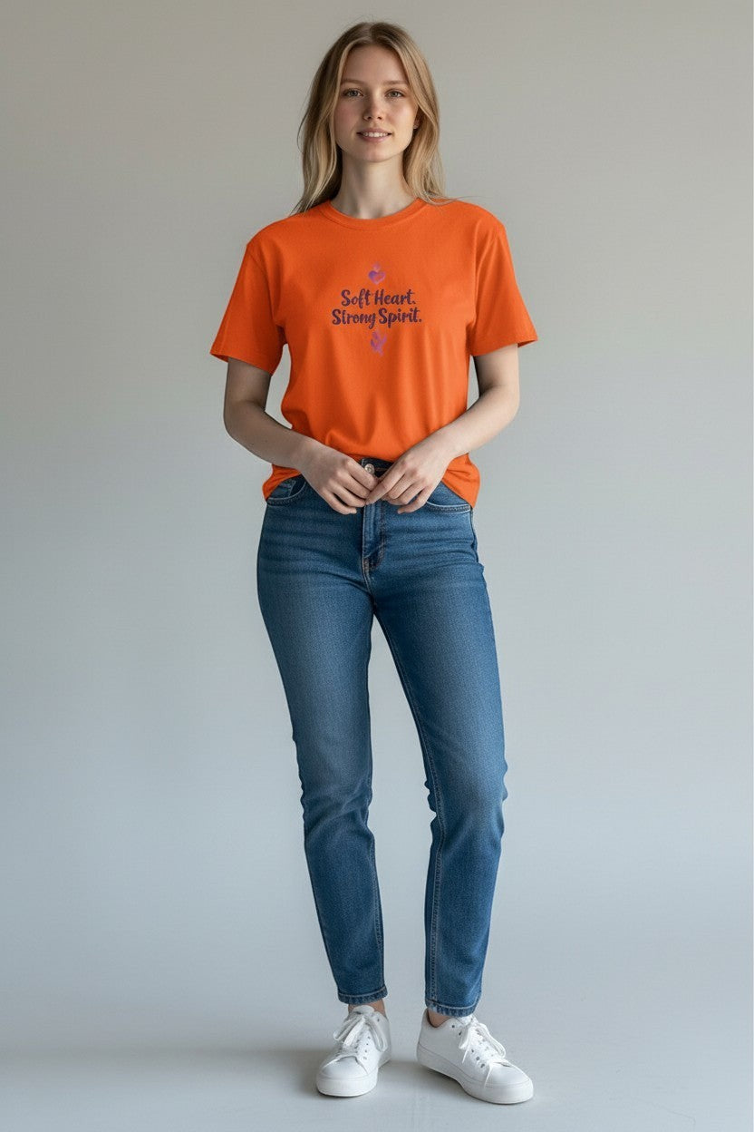 Woman wearing orange “Soft Heart Strong Spirit” t-shirt, a bold and uplifting casual outfit.