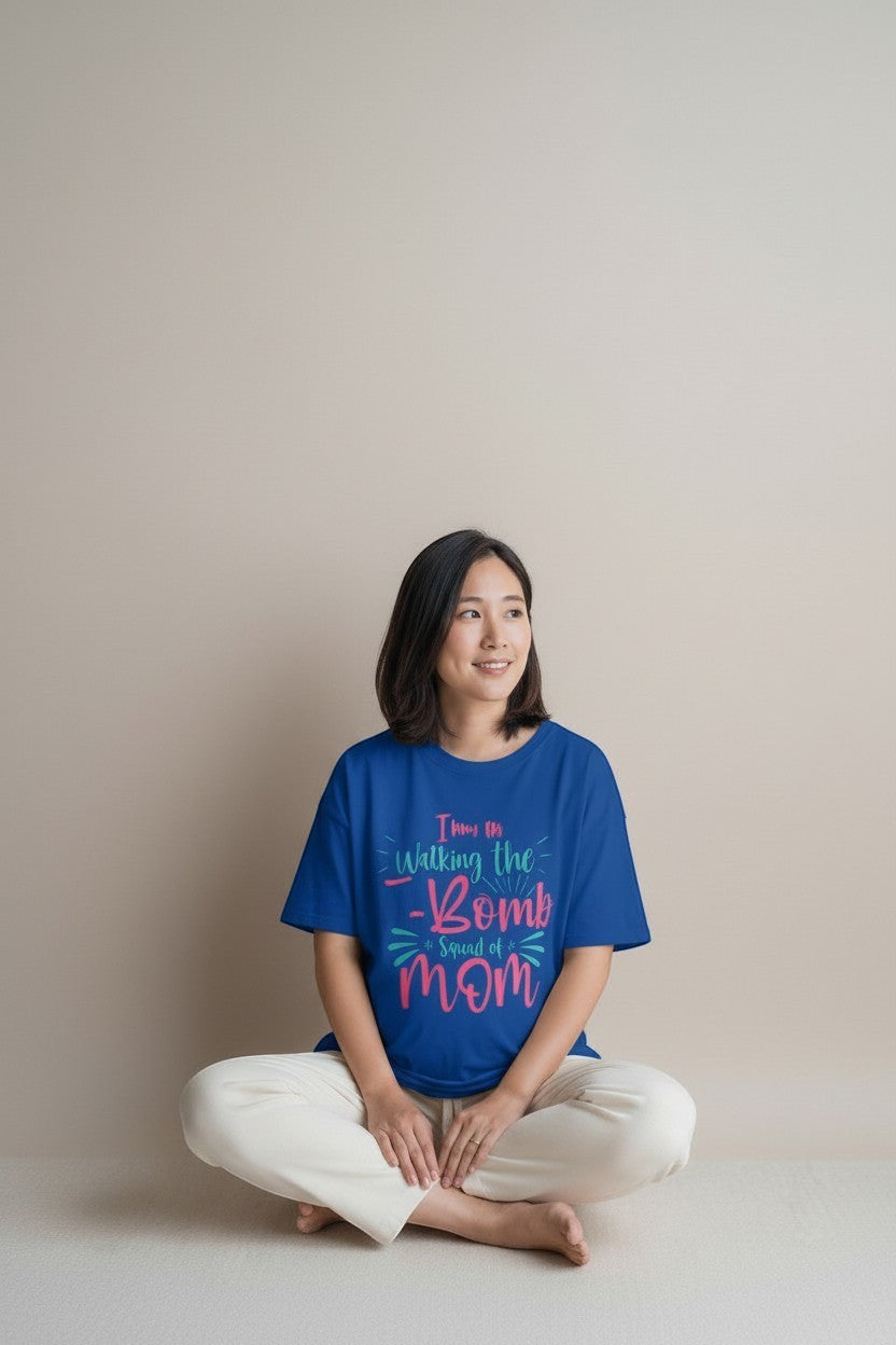 Woman sitting wearing royal blue “Drop the F-Bomb Mom” t-shirt, a chill and relatable mom vibe.