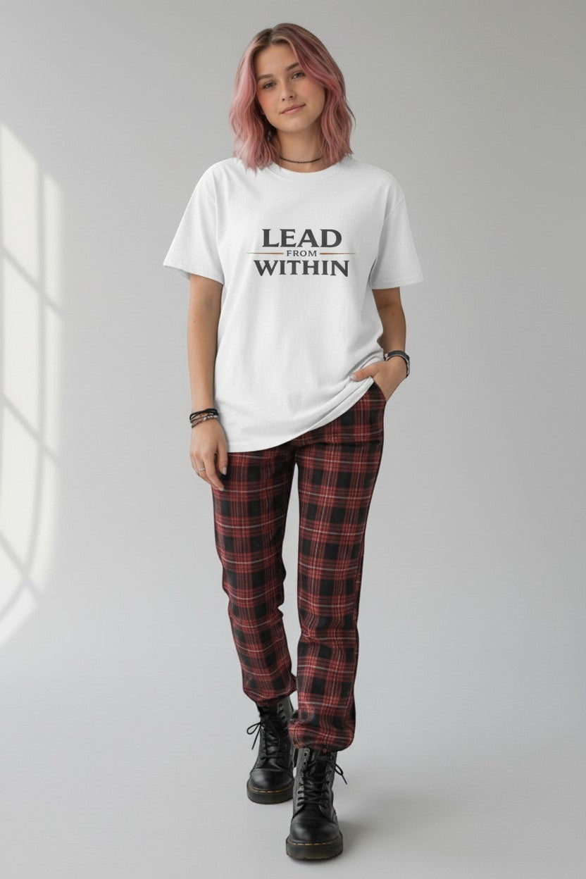 Woman wearing white “Lead From Within” t-shirt styled with plaid pants, a bold and modern casual look.