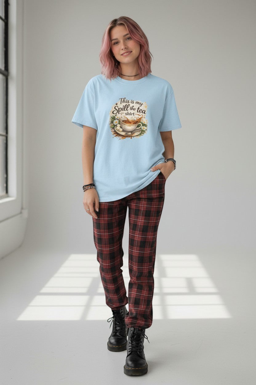Woman wearing light blue “Spill the Tea” t-shirt styled with a trendy casual outfit, perfect for relaxed everyday wear.