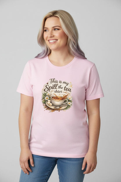 Woman wearing a pink “Spill the Tea” shirt, a cute and playful graphic tee perfect for tea lovers and cozy outfits.