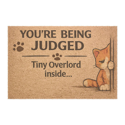 Clean product image of “You’re Being Judged – Tiny Overlord Inside” cat doormat, perfect for cat lovers and humorous home decor.