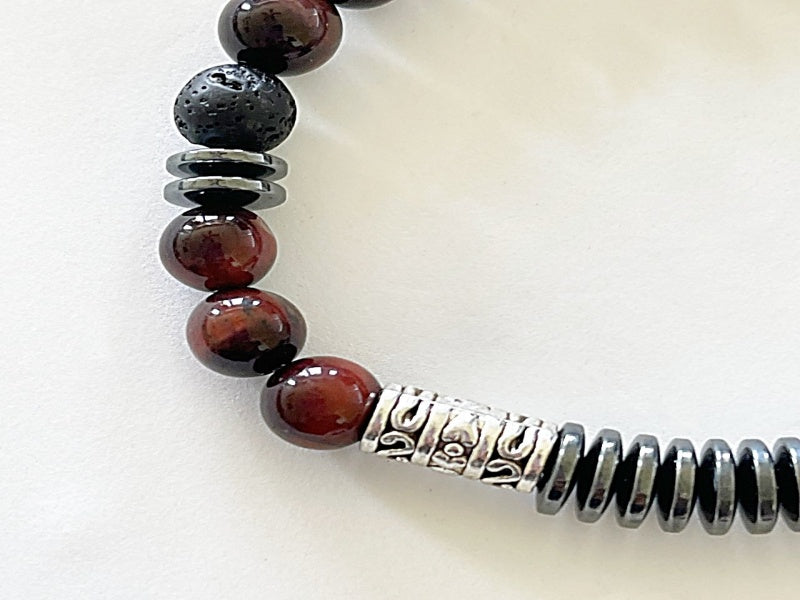 8" stretch bracelet made with lava stone, hematite, and tiger's eye with base metal spacers reads Focus in morse code