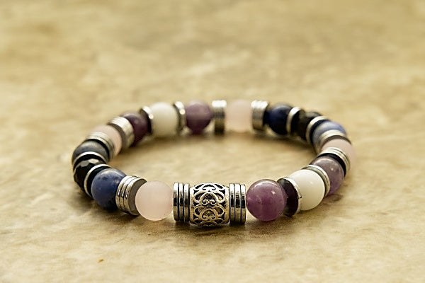 Bracelet with purple amethyst, white jade and blue sodalite beads on stretch cord with disk shaped base metal spacers