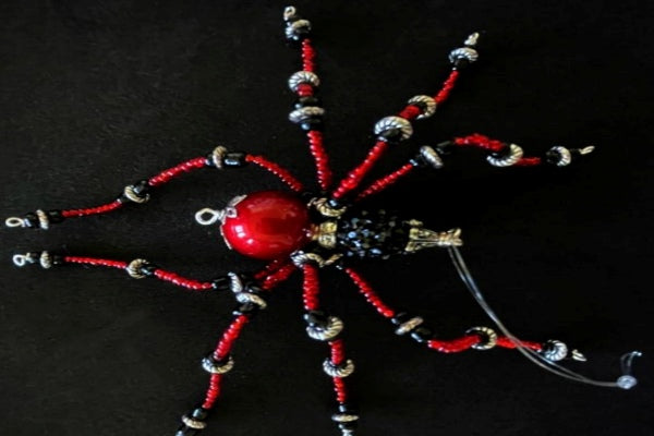Black and Red Christmas spider with black bead head and red bead body, with red and black glass seed beads with metal spacers for the legs